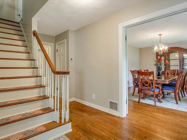 211 Country Club Ln, Belleville, IL 62223 - staircase featuring wood finished floors, a chandelier, and baseboards