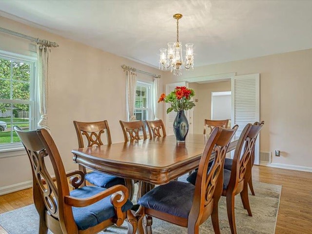 211 Country Club Ln, Belleville, IL 62223 - dining room with a chandelier, light wood-type flooring, and baseboards