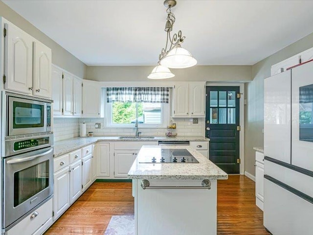 211 Country Club Ln, Belleville, IL 62223 - kitchen featuring appliances with stainless steel finishes, a sink, white cabinets, and tasteful backsplash