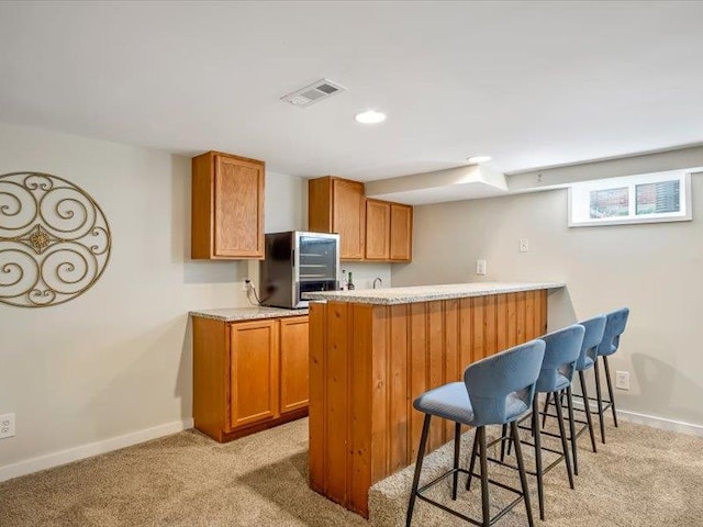 211 Country Club Ln, Belleville, IL 62223 - kitchen featuring light colored carpet, brown cabinetry, a breakfast bar area, and recessed lighting