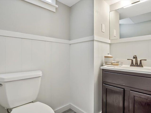 211 Country Club Ln, Belleville, IL 62223 - bathroom featuring vanity, toilet, a wainscoted wall, and a decorative wall
