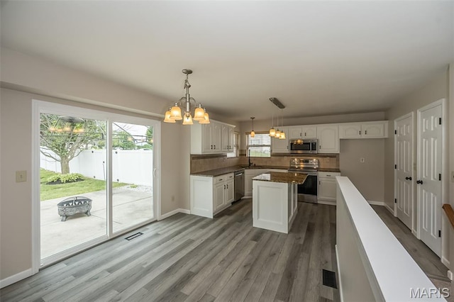 403 Autumn Farms Ct, Wentzville, MO 63385 - kitchen with appliances with stainless steel finishes, a chandelier, white cabinets, backsplash, and dark countertops