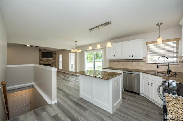 403 Autumn Farms Ct, Wentzville, MO 63385 - kitchen featuring stainless steel appliances, open floor plan, dark stone counters, a kitchen island, and white cabinetry