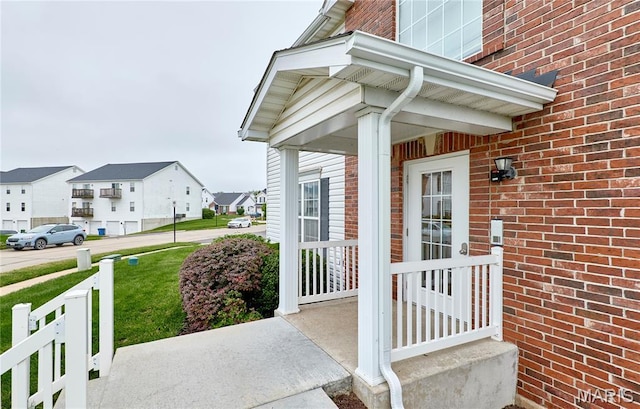 9 Homefield Gardens Dr Unit 31N, Ofallon, MO 63366 - view of exterior entry with brick siding, a residential view, covered porch, and a yard