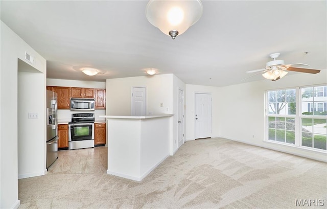 9 Homefield Gardens Dr Unit 31N, Ofallon, MO 63366 - kitchen featuring stainless steel appliances, light carpet, brown cabinets, light countertops, and baseboards