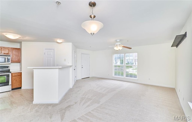 9 Homefield Gardens Dr Unit 31N, Ofallon, MO 63366 - kitchen featuring appliances with stainless steel finishes, brown cabinets, ceiling fan, and light colored carpet