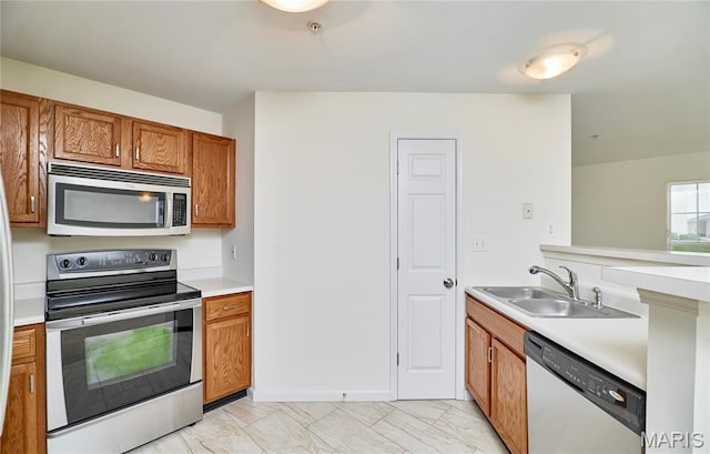 9 Homefield Gardens Dr Unit 31N, Ofallon, MO 63366 - kitchen with stainless steel appliances, a sink, brown cabinets, light countertops, and light marble finish flooring