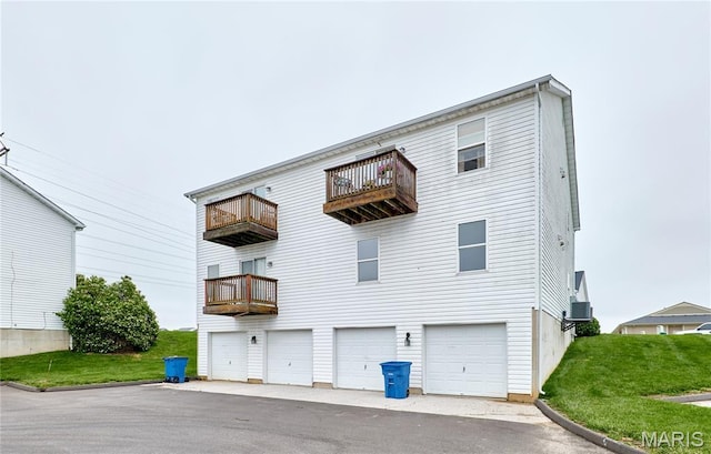 9 Homefield Gardens Dr Unit 31N, Ofallon, MO 63366 - rear view of house with a balcony, an attached garage, and a lawn