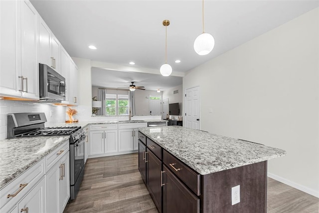 3516 Broad St, Saint Charles, MO 63301 - kitchen featuring appliances with stainless steel finishes, a sink, wood finished floors, backsplash, and recessed lighting