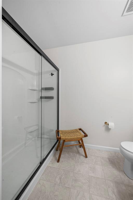 3516 Broad St, Saint Charles, MO 63301 - bathroom with a shower stall, toilet, and baseboards