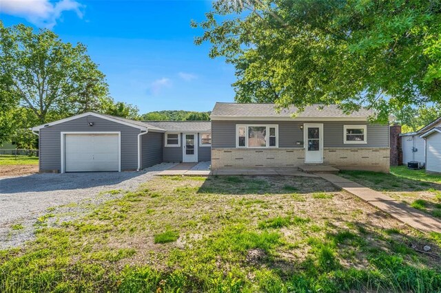 418 Williams St, Pacific, MO 63069 - view of front of home featuring brick siding, gravel driveway, a garage, and a front yard