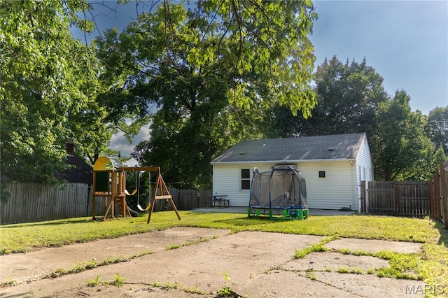 108 Tomlinson St, East Alton, IL 62024 - back of property with a trampoline, a playground, a patio, and a fenced backyard