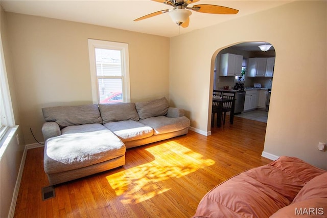 108 Tomlinson St, East Alton, IL 62024 - living room with arched walkways, ceiling fan, and light wood-style flooring