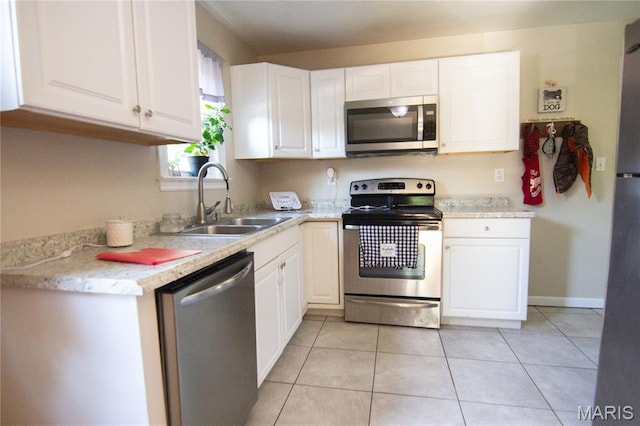 108 Tomlinson St, East Alton, IL 62024 - kitchen with stainless steel appliances, white cabinetry, light countertops, and light tile patterned floors