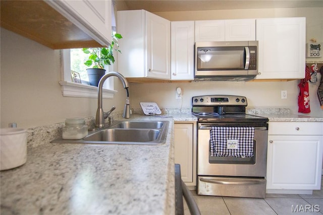 108 Tomlinson St, East Alton, IL 62024 - kitchen with stainless steel appliances, light countertops, white cabinetry, and light tile patterned flooring