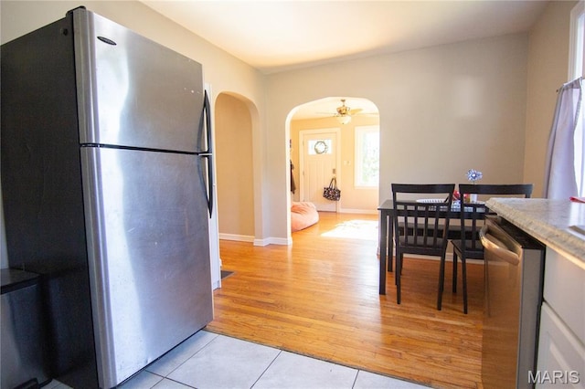 108 Tomlinson St, East Alton, IL 62024 - kitchen featuring appliances with stainless steel finishes, arched walkways, light tile patterned floors, and ceiling fan