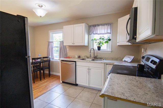 108 Tomlinson St, East Alton, IL 62024 - kitchen with stainless steel appliances, white cabinetry, light countertops, and light tile patterned floors