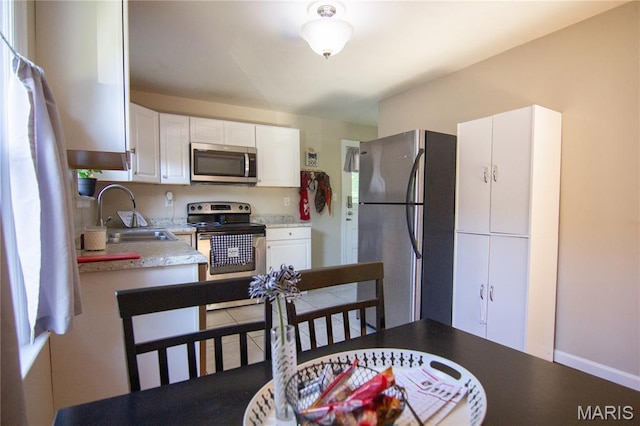 108 Tomlinson St, East Alton, IL 62024 - kitchen with appliances with stainless steel finishes, white cabinetry, and light countertops