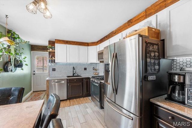 2851 Quenley St, Saint Charles, MO 63301 - kitchen featuring stainless steel appliances, a sink, decorative backsplash, white cabinetry, and light wood-type flooring