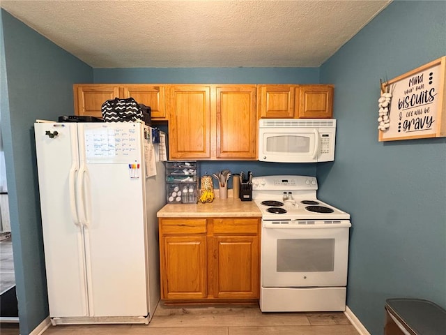 711 N Lindell St, Vandalia, MO 63382 - kitchen with white appliances, light wood-style flooring, light countertops, and a textured ceiling
