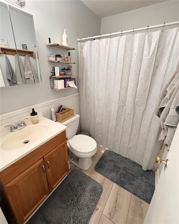 711 N Lindell St, Vandalia, MO 63382 - bathroom featuring vanity, wood finished floors, toilet, and a shower with curtain