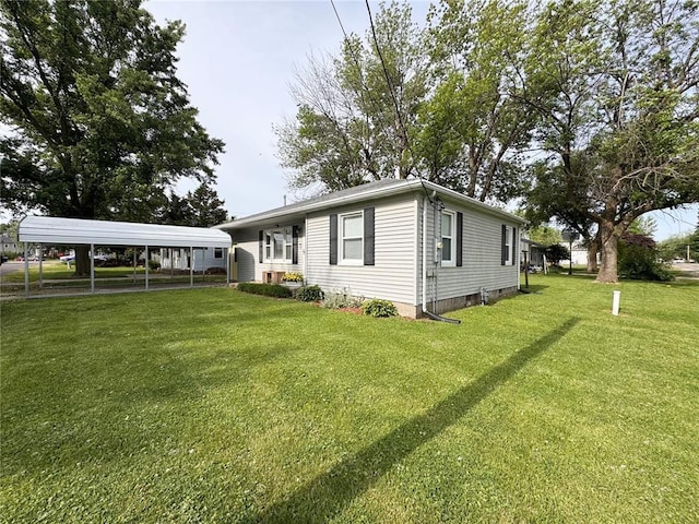 711 N Lindell St, Vandalia, MO 63382 - view of side of home featuring a detached carport and a lawn