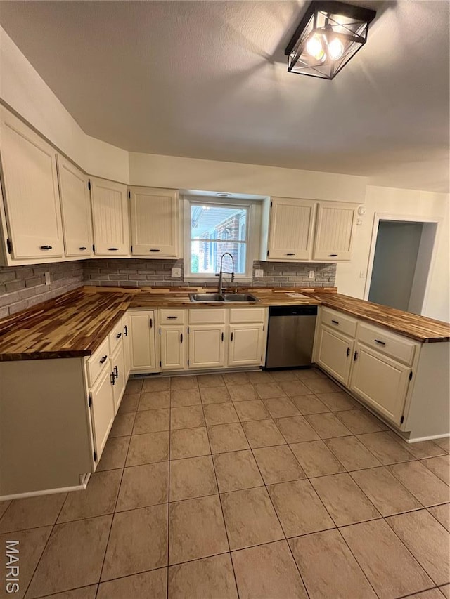 1319 W Main St, Bowling Green, MO 63334 - kitchen featuring stainless steel dishwasher, a sink, backsplash, butcher block countertops, and light tile patterned floors