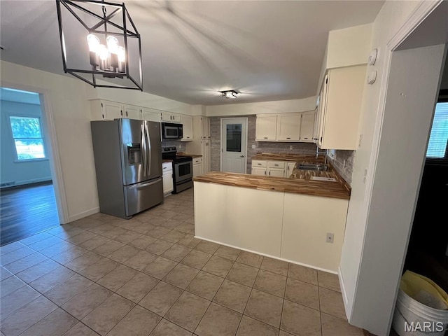 1319 W Main St, Bowling Green, MO 63334 - kitchen with appliances with stainless steel finishes, a sink, wooden counters, and tile patterned floors