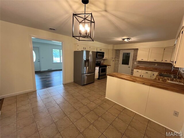 1319 W Main St, Bowling Green, MO 63334 - kitchen featuring stainless steel appliances, a sink, tile patterned flooring, dark countertops, and tasteful backsplash