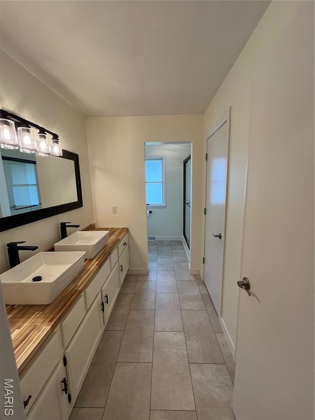 1319 W Main St, Bowling Green, MO 63334 - full bathroom with double vanity, a shower with door, baseboards, and tile patterned flooring