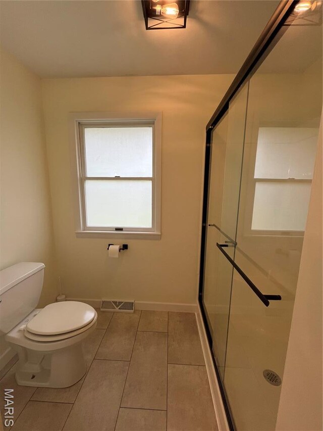 1319 W Main St, Bowling Green, MO 63334 - bathroom with toilet, a shower stall, tile patterned floors, and baseboards
