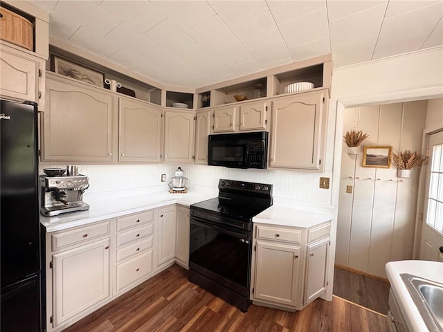 517 W Olive St, Palmyra, MO 63461 - kitchen with black appliances, dark wood-type flooring, and light countertops