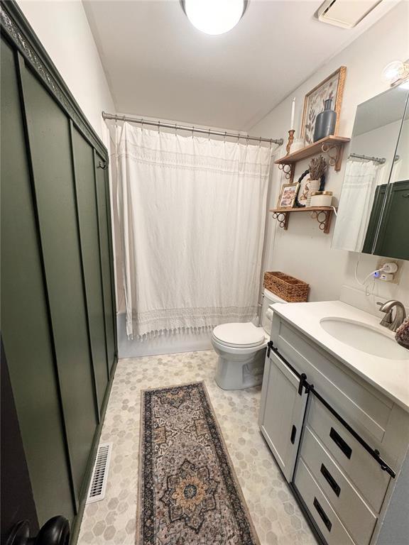 517 W Olive St, Palmyra, MO 63461 - full bathroom with tile patterned floors, vanity, toilet, and curtained shower