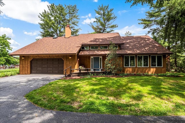 513 Matthews Ln, Waterloo, IL 62298 - view of front of house with a garage, a front yard, asphalt driveway, covered porch, and a chimney