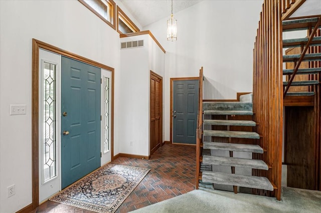 513 Matthews Ln, Waterloo, IL 62298 - foyer featuring stairs, brick flooring, baseboards, a chandelier, and a towering ceiling