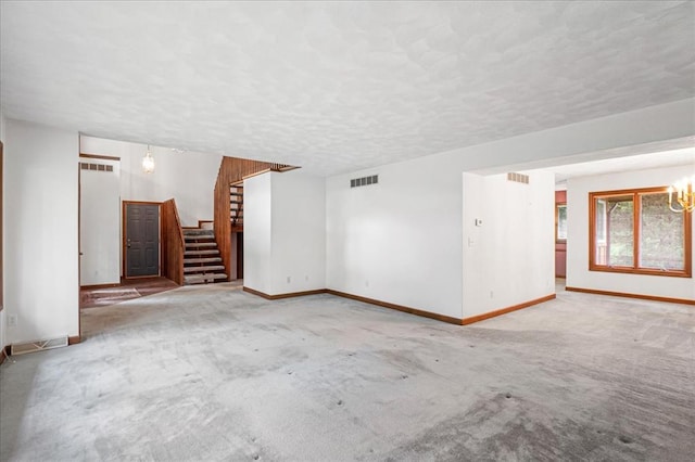 513 Matthews Ln, Waterloo, IL 62298 - unfurnished living room featuring stairway, baseboards, a chandelier, carpet, and a textured ceiling