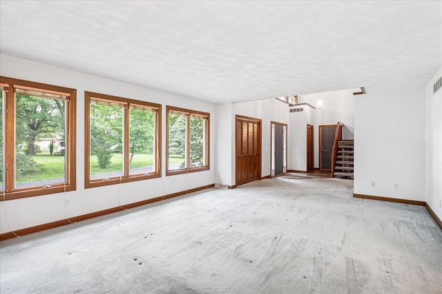 513 Matthews Ln, Waterloo, IL 62298 - unfurnished living room with plenty of natural light, baseboards, stairs, and light colored carpet