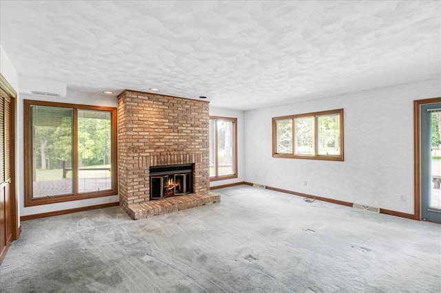 513 Matthews Ln, Waterloo, IL 62298 - unfurnished living room with healthy amount of natural light, baseboards, a brick fireplace, and a textured ceiling