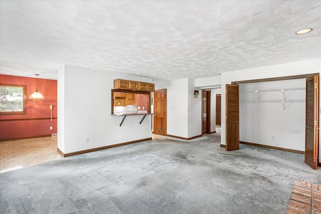 513 Matthews Ln, Waterloo, IL 62298 - unfurnished living room with baseboards, a textured ceiling, and light colored carpet