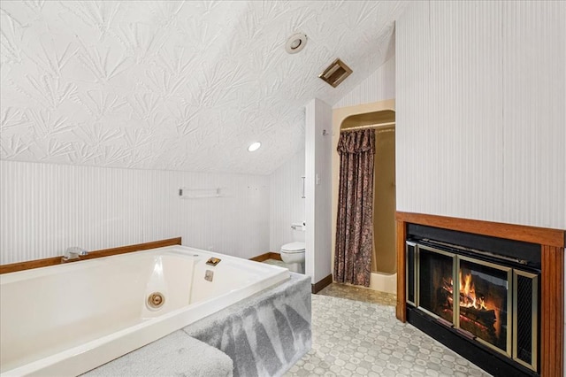 513 Matthews Ln, Waterloo, IL 62298 - bathroom featuring a jetted tub, lofted ceiling, toilet, a glass covered fireplace, and a shower with shower curtain