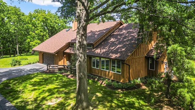 513 Matthews Ln, Waterloo, IL 62298 - view of front of home with a front yard, asphalt driveway, roof with shingles, and board and batten siding