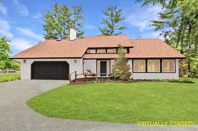 513 Matthews Ln, Waterloo, IL 62298 - view of front of home with an attached garage, a front yard, asphalt driveway, a chimney, and a shingled roof
