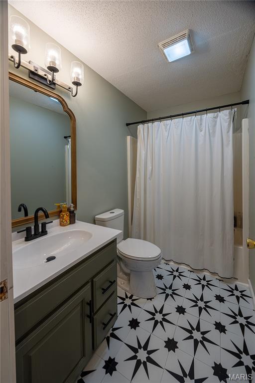 781 N W Ln, Jackson, MO 63755 - full bath with vanity, tile patterned floors, toilet, a textured ceiling, and shower / tub combo
