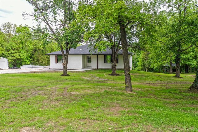 405 Julie Ln, Holts Summit, MO 65043 - view of front facade with a front yard, stucco siding, and roof with shingles