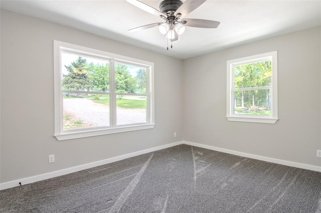 405 Julie Ln, Holts Summit, MO 65043 - unfurnished room with healthy amount of natural light, ceiling fan, dark colored carpet, and baseboards