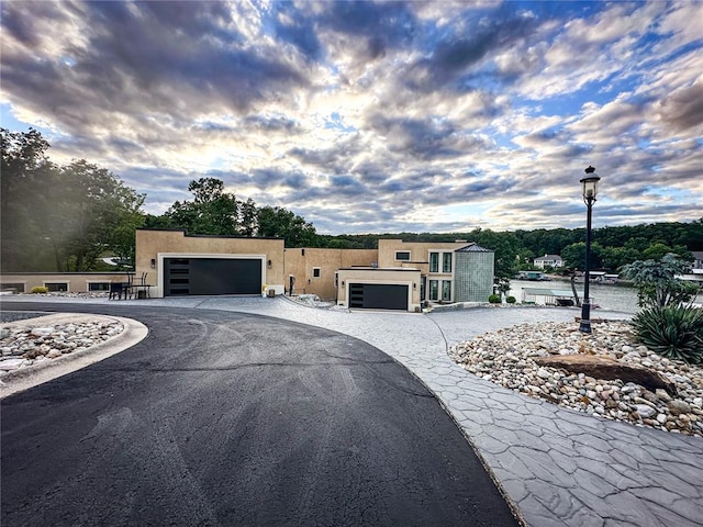 149 Thornwood Cir, Sunrise Beach, MO 65079 - view of front of property featuring stucco siding, asphalt driveway, and a garage