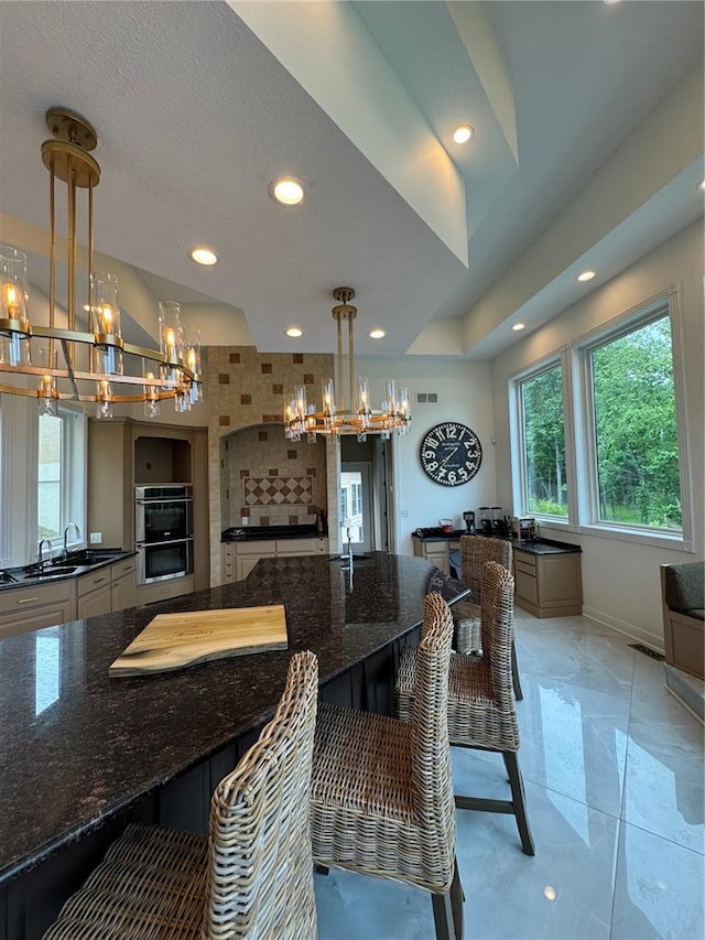 149 Thornwood Cir, Sunrise Beach, MO 65079 - kitchen featuring a chandelier, double oven, recessed lighting, dark stone countertops, and a breakfast bar