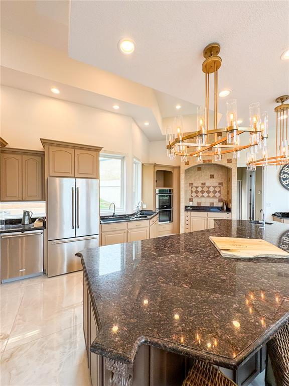 149 Thornwood Cir, Sunrise Beach, MO 65079 - kitchen featuring appliances with stainless steel finishes, a chandelier, a sink, dark stone counters, and recessed lighting