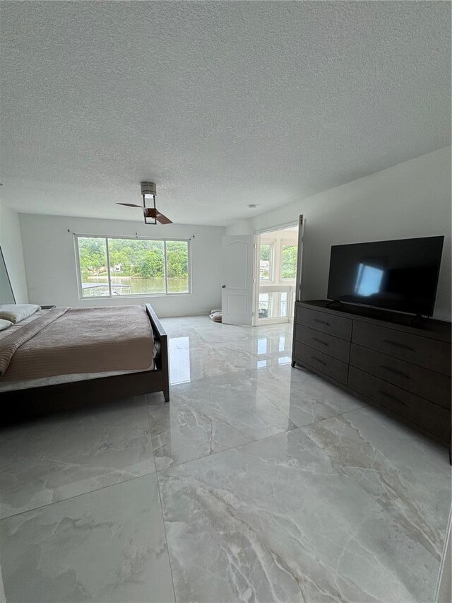 149 Thornwood Cir, Sunrise Beach, MO 65079 - unfurnished bedroom with light marble finish floors, a textured ceiling, and a ceiling fan
