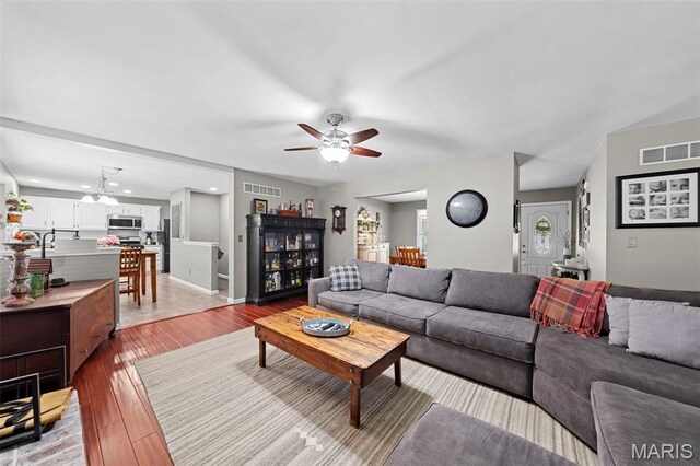 2917 Royal Gorge Ct, Oakville Township, MO 63129 - living room featuring ceiling fan, light wood finished floors, and baseboards